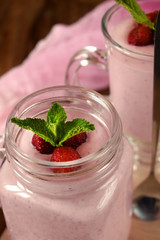 Protein cocktail with strawberries and mint in a glass jar