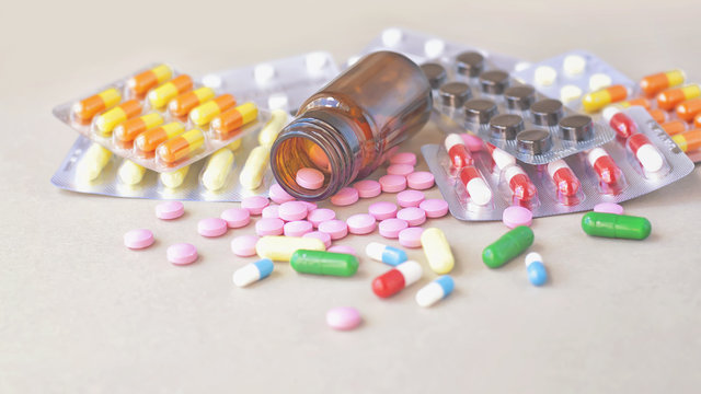 Composition of medicine bottle and pills on gray background. 