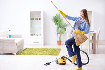 Young woman cleaning floor at home doing chores