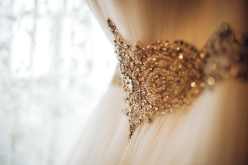 Pretty white wedding dress hang in the bride’s room