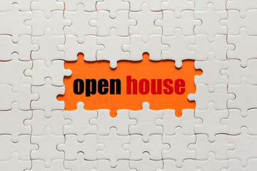 White details of puzzle on orange background and word Open House