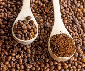 Two spoons with beans and ground coffee