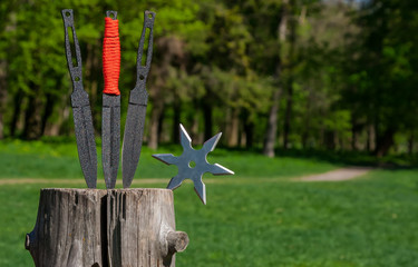 Throwing knife and Shuriken (throwing star), on wooden background.