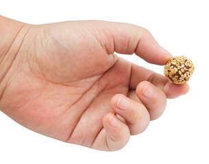 Hand Holding Chocolate Candy Ball with Sesame