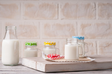 Milk jars with colorful caps on a cutting board 