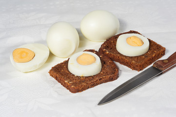 Eggs and two pieces of rye bread on the white napkin