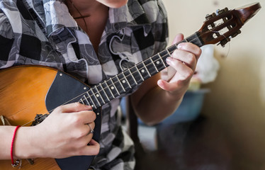 Hands of a musician playing on domra tremolo. Hands of the musician on the move. Selective focus.