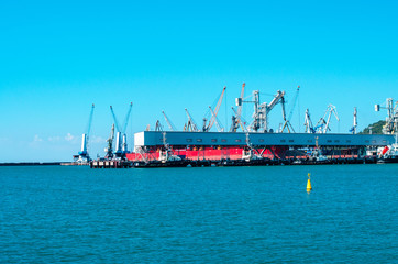 Shipyard and cranes on blue sky and sea background