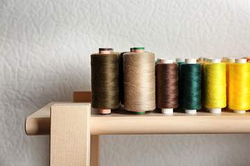 Fototapeta na wymiar Set of color sewing threads on wooden shelf