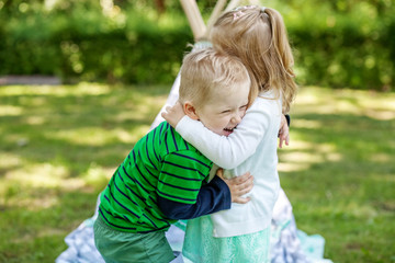 Children preschoolers embrace and play in the park. Girl and boy. The concept is childhood and family.