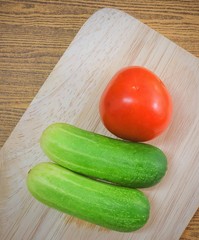 Fresh Tomato with Cucumbers on Cutting Board