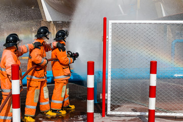 Obraz premium Fire fighter in full gear standing outside a steel building ready to go in.