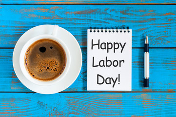 Happy labor Day - message in notepad at blue rustic table with morning coffee cup. Labour day...