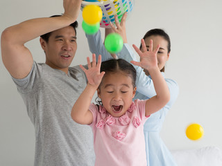 young Asian Kid playing colorful ball.