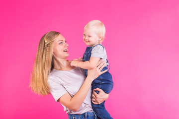 happy little girl and her mother having fun over pink background
