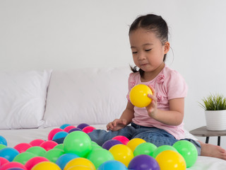 young Asian Kid playing colorful ball.