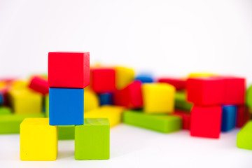 Colorful wooden building toy blocks isolated on a white background