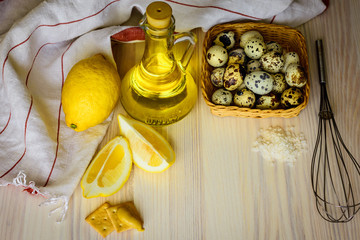 Ingredients for cooking sauce mayonnaise from quail eggs. Basket with eggs, lemon, oil.
