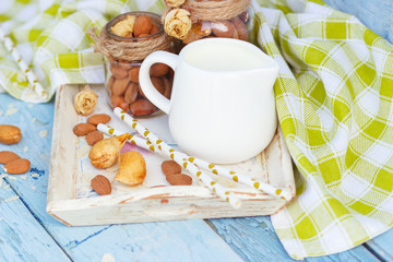 Almonds and jar with milk on the wooden tray
