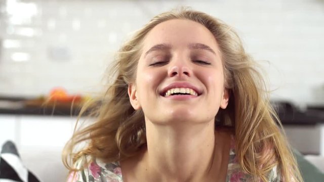 Young woman alone at living room sitting closed eyes joyful