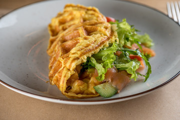 A photo of an omelet with with salad Iceberg, salmon and greens. Best breakfast for good day beginning