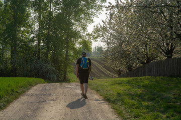 Adult man walking in sport clothing on the forest road, springtime in Haspengouw, Belgium