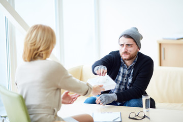 Obraz premium Female psychologist offering handkerchief to young migrant during psychological session