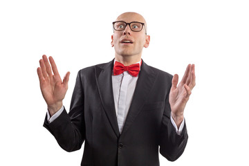 Slim bald elegant nerd with glasses and bow tie looking at the camera with the gesture of astonishment. Isolated on white.