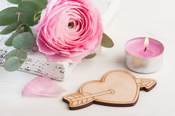 Pink buttercup flower with wooden heart