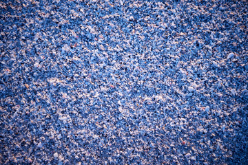 Wet coarse textured beach sand at sunset