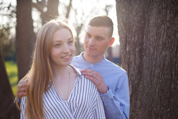 Fototapeta premium Young man surprising his girlfriend hugging her shoulders