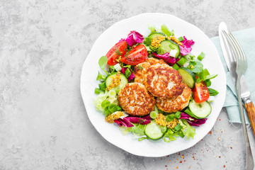 Cutlets and fresh vegetable salad on white plate. Fried meatballs with vegetable salad
