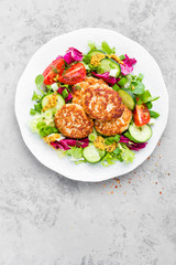 Cutlets and fresh vegetable salad on white plate. Fried meatballs with vegetable salad