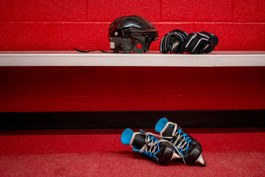 Hockey skates, helmet and gloves in locker room with copy space 