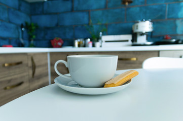 A cup of tea and a saucer on the table in the kitchen