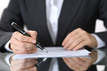 Close-up of female hands with pen over document,  business concept