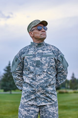 Courageous brave soldier. Portrait of mature sergeant with spectacles and cap outdoor.