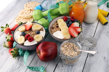 muesli with dairy and fruit, healthy lifestyle. bowl of cereal, fruit and dumbbell