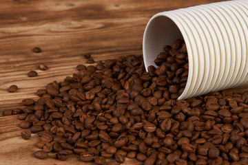 Take away coffee paper cups and roasted coffee beans on rustic wooden table background, close-up.