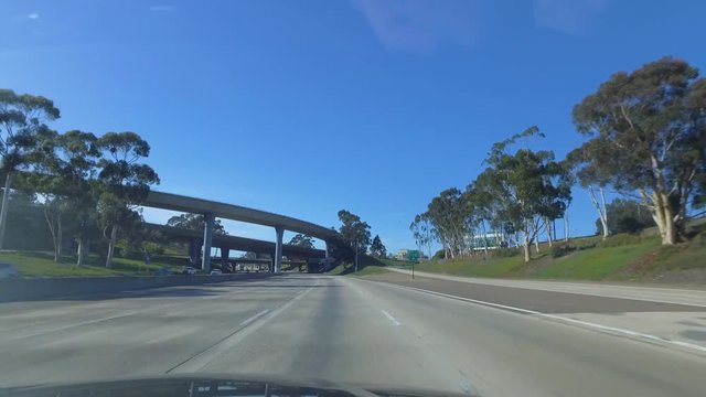 another day POV shot driving under series of overpasses on CA freeway