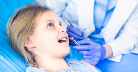 Fototapeta premium Little girl sitting in the dentists office
