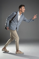 Punctuality concept. Side view profile of pleased good looking man running with backpack