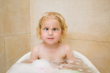 Little cute baby is playing in the bathroom