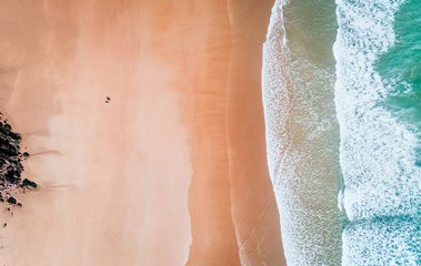 Luchtfoto van een surfer die uit het water komt op een strand in Asturië