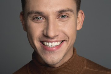 Portrait of young male person with groomed skin and white smile. Isolated on background