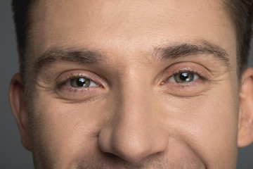 Close up of male light eyes staring at camera. Man is smiling