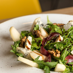 Leaf vegetable salad with cheese, grapes, walnuts and tasty sauce. Healthy, diet food