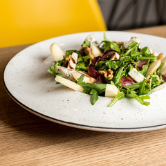 Leaf vegetable salad with cheese, grapes, walnuts and tasty sauce. Healthy, diet food