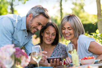 summer. Group of friends gathered around a table in the garden