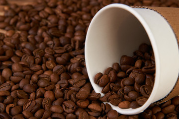 Take away coffee paper cups and roasted coffee beans on rustic wooden table background, close-up.